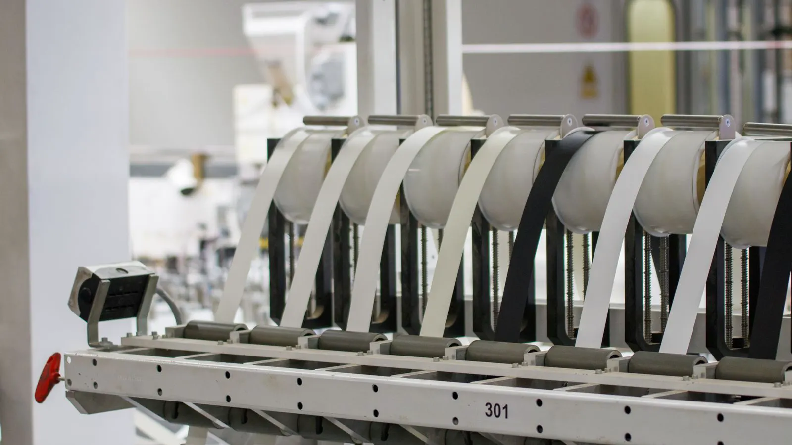 A pneumatic linear slide mounted on a steel machine frame with visible tubing.