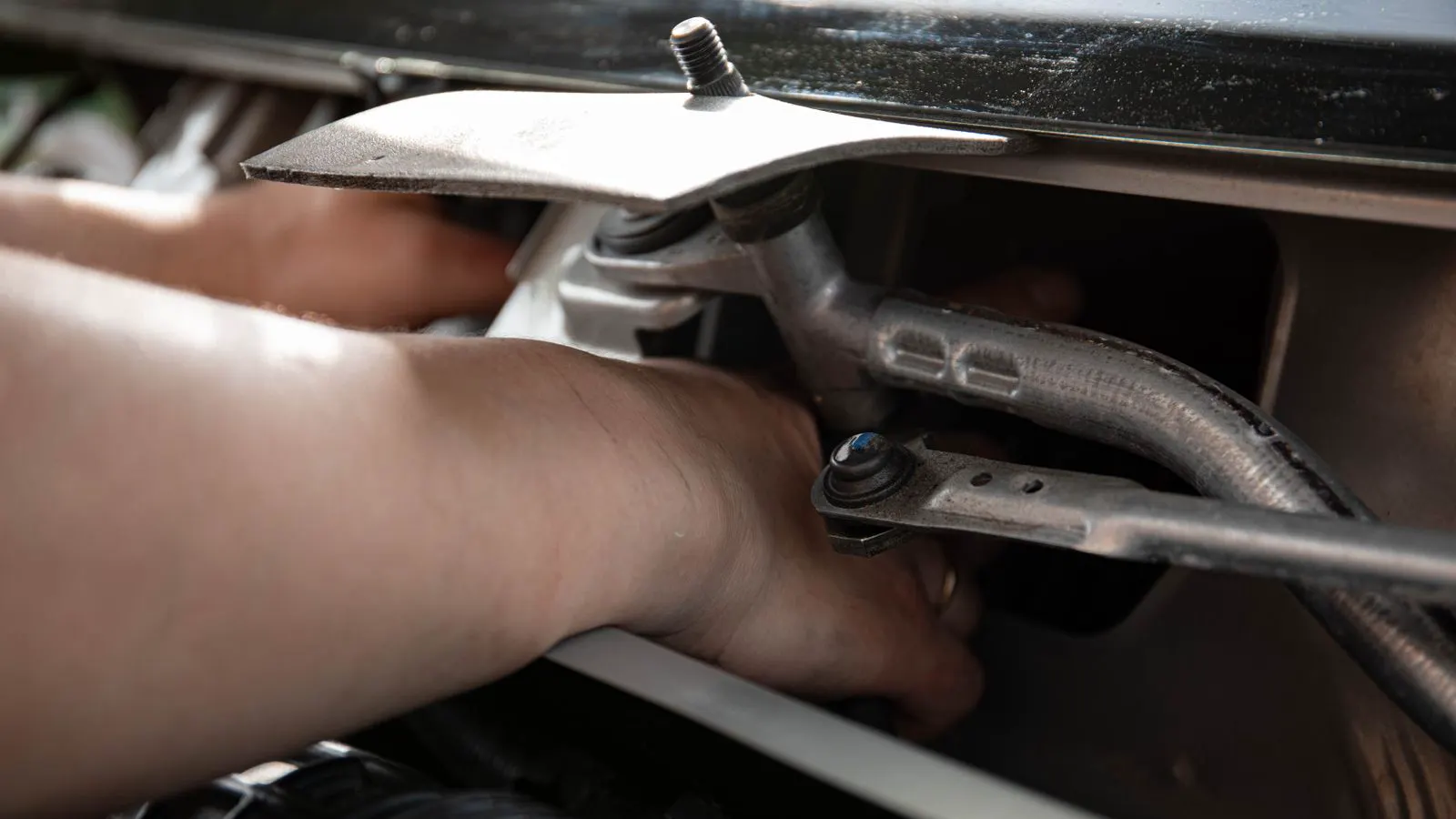 Technician applies grease to a linear motion rail with a small brush.