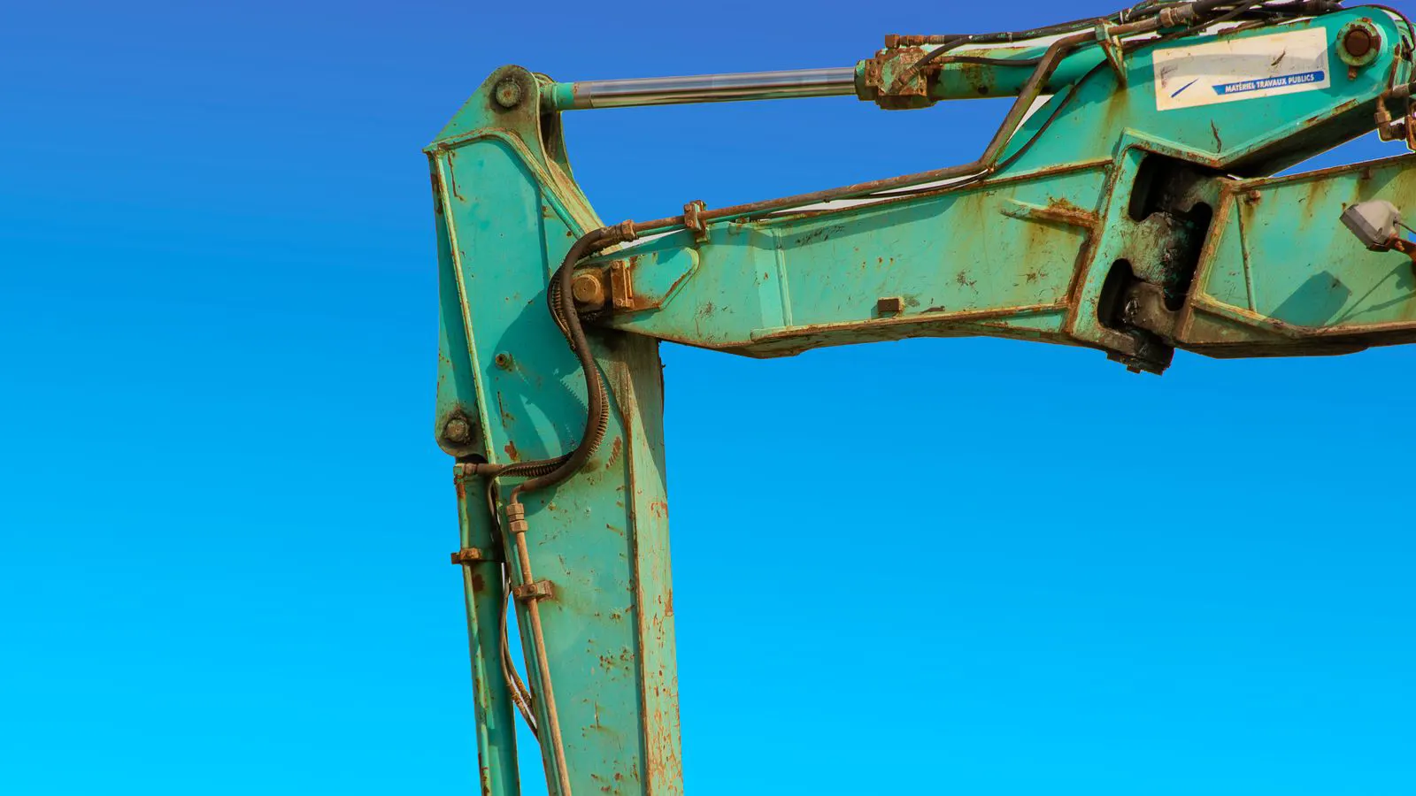 A hydraulic cylinder with a sizing chart displayed on a workbench.