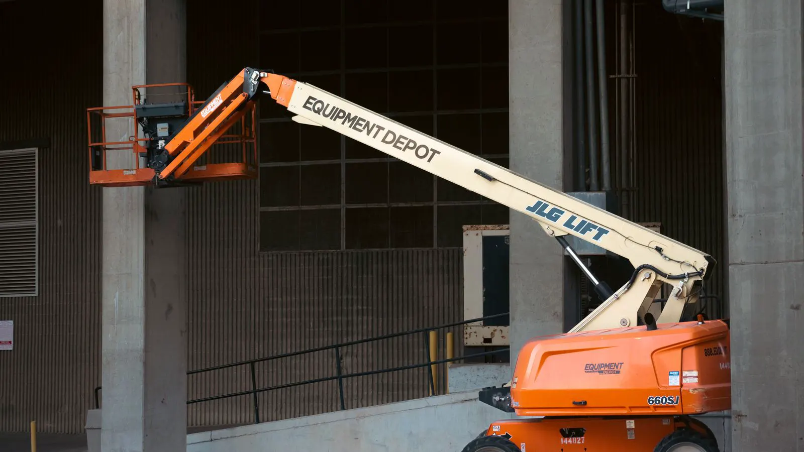 A vertical pneumatic cylinder lifting a metal load in a workshop