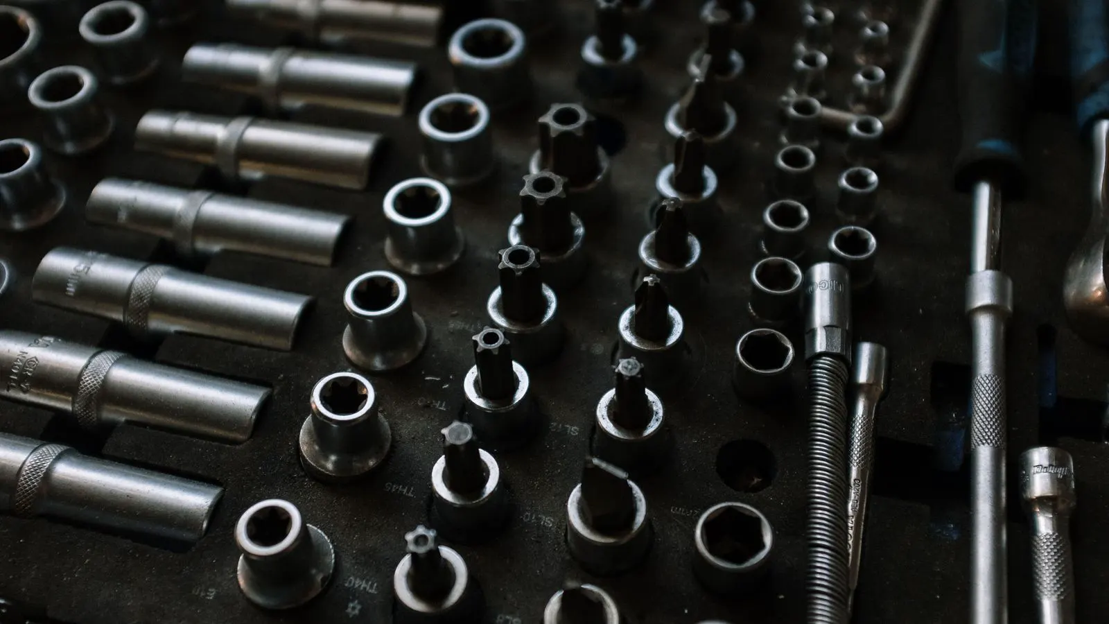 Close-up of an engineer checking hex bolts with a thread gauge and calipers.