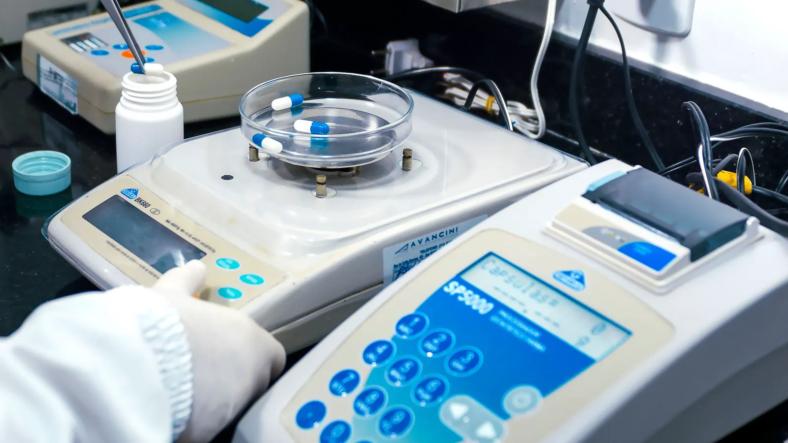 A technical laboratory setup with testing instruments and metal fasteners on a bench.