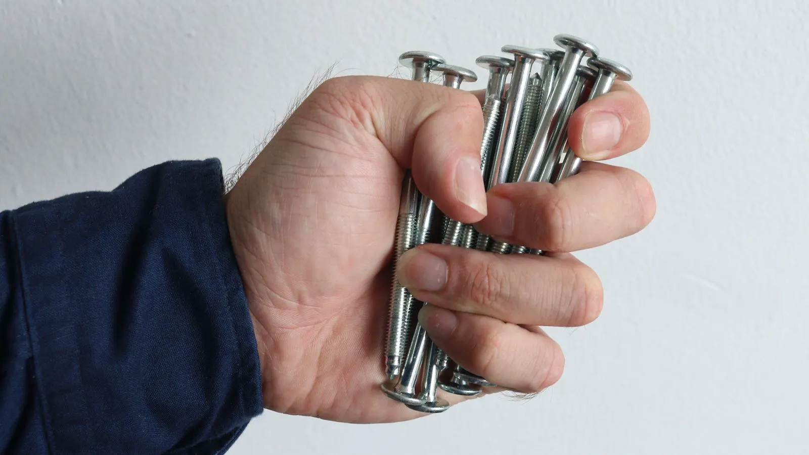 Close-up of steel bolts arranged on a metal inspection tray