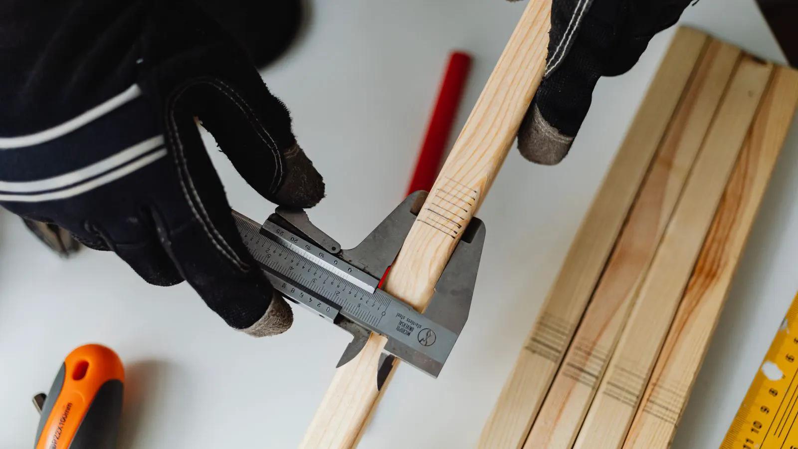 Caliper measuring a bolt head dimension on a workbench