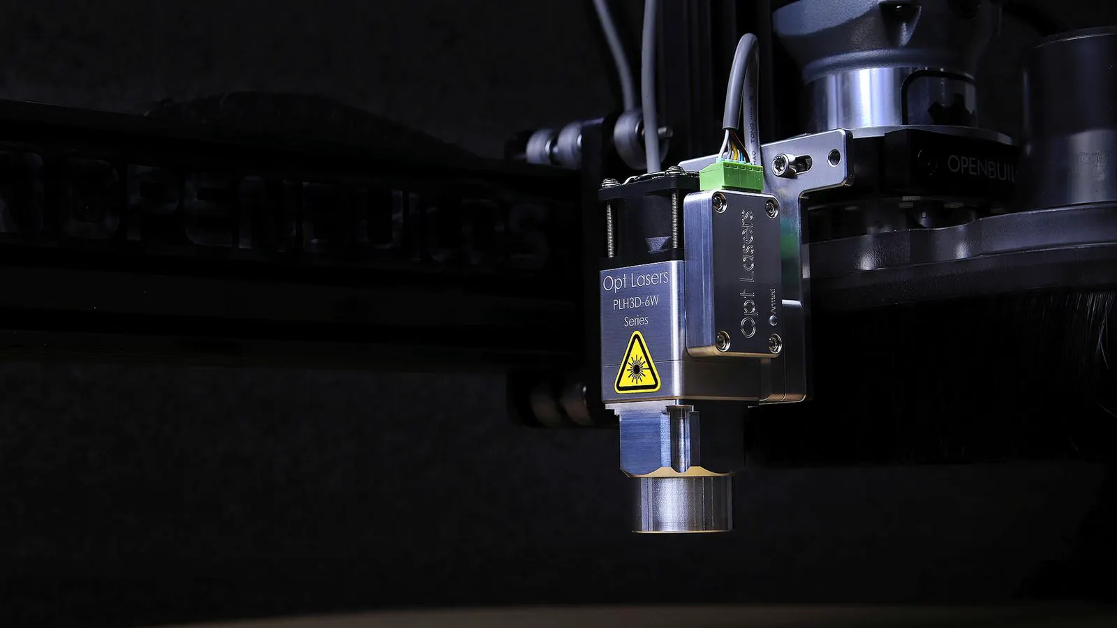 Close view of a laser head cutting through a sheet of acrylic