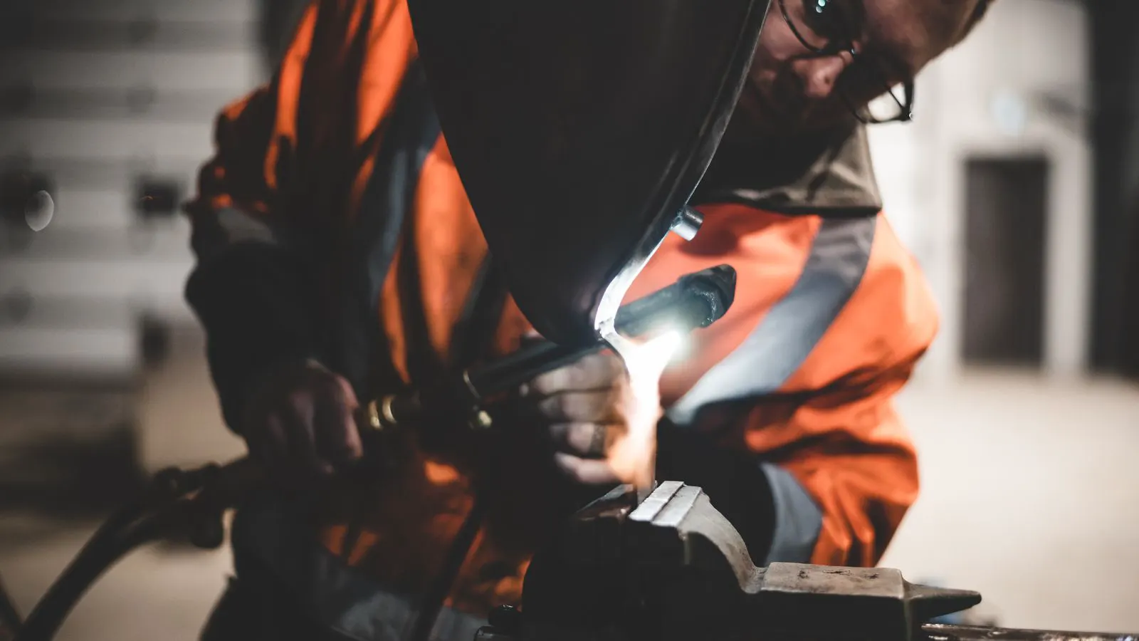 An engineer inspects a welding helmet lens for damage