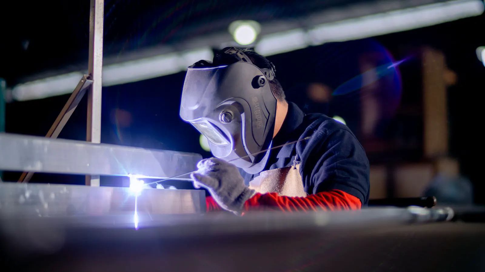 A steel welding enclosure with transparent panels in a factory