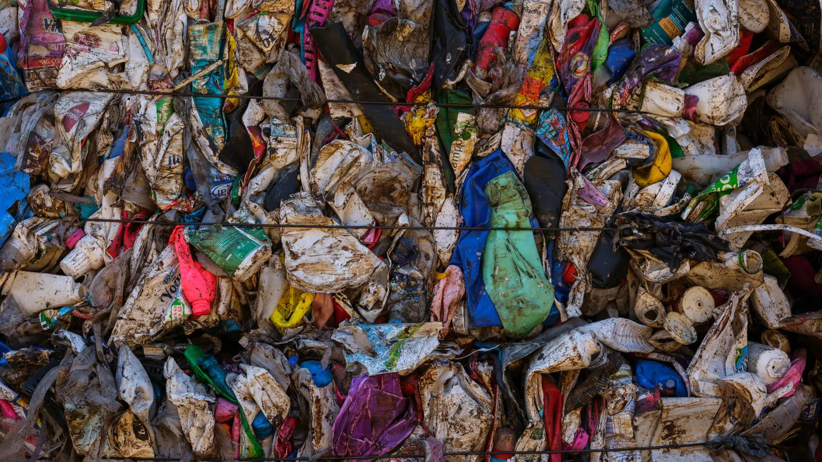 A large steel bale of compressed material sits on a factory floor.