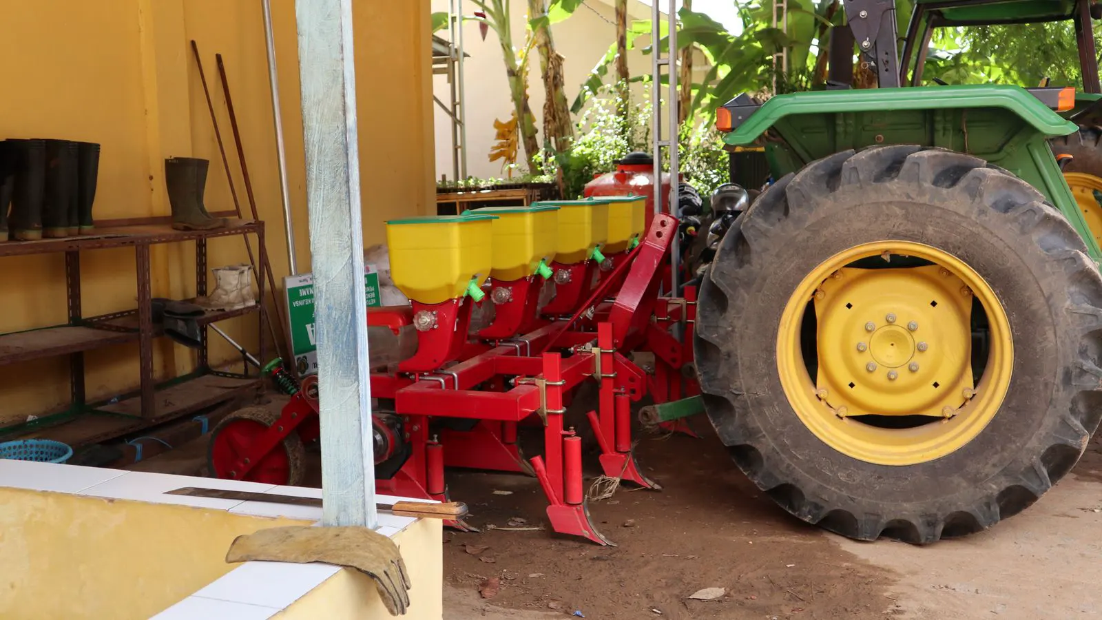 A close view of a row unit with soil on it during maintenance.