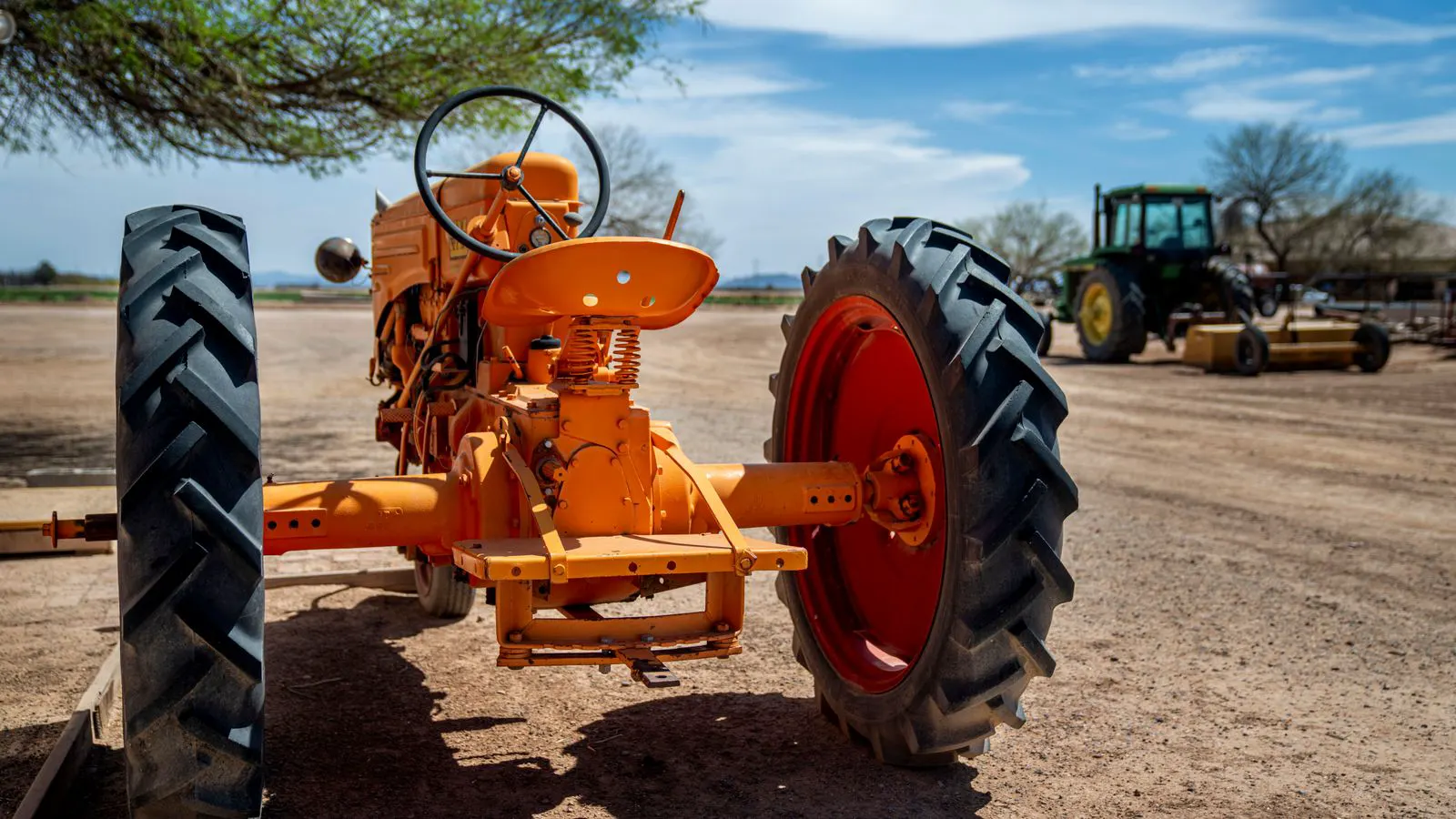 Farm equipment parked in a dealer yard with service van nearby.