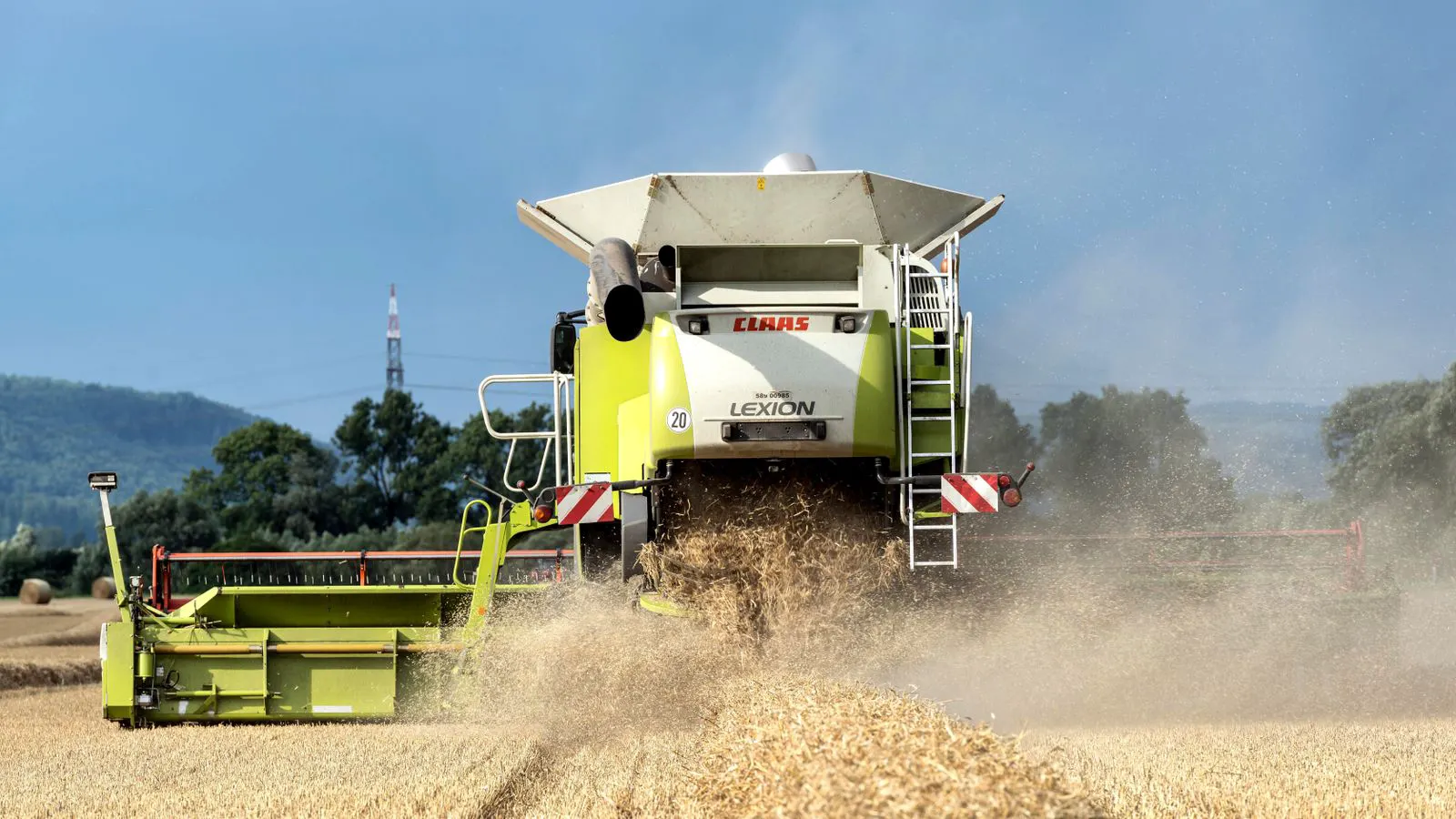 A large combine harvester working in a grain field