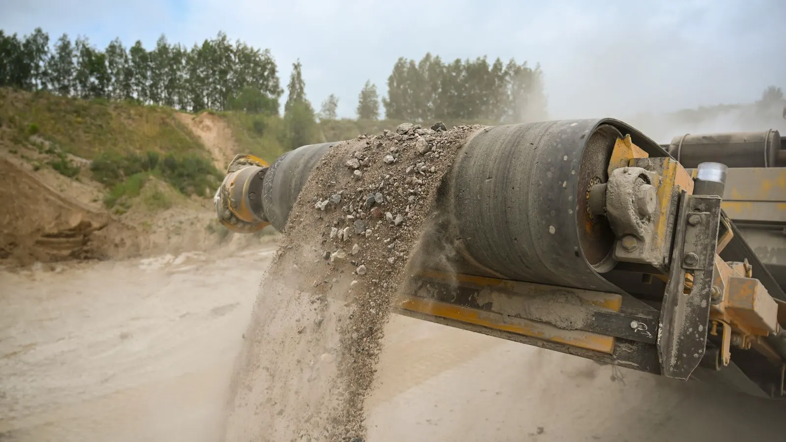 A long belt conveyor carrying ore across a mine site.
