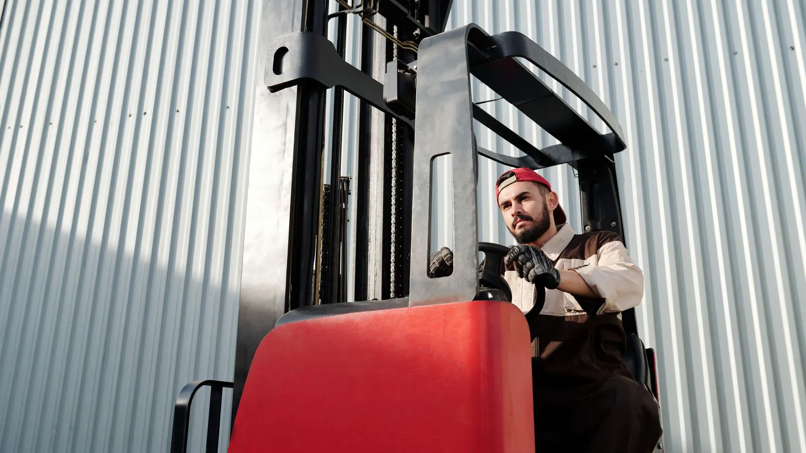 A technician uses a clipboard to inspect a forklift.