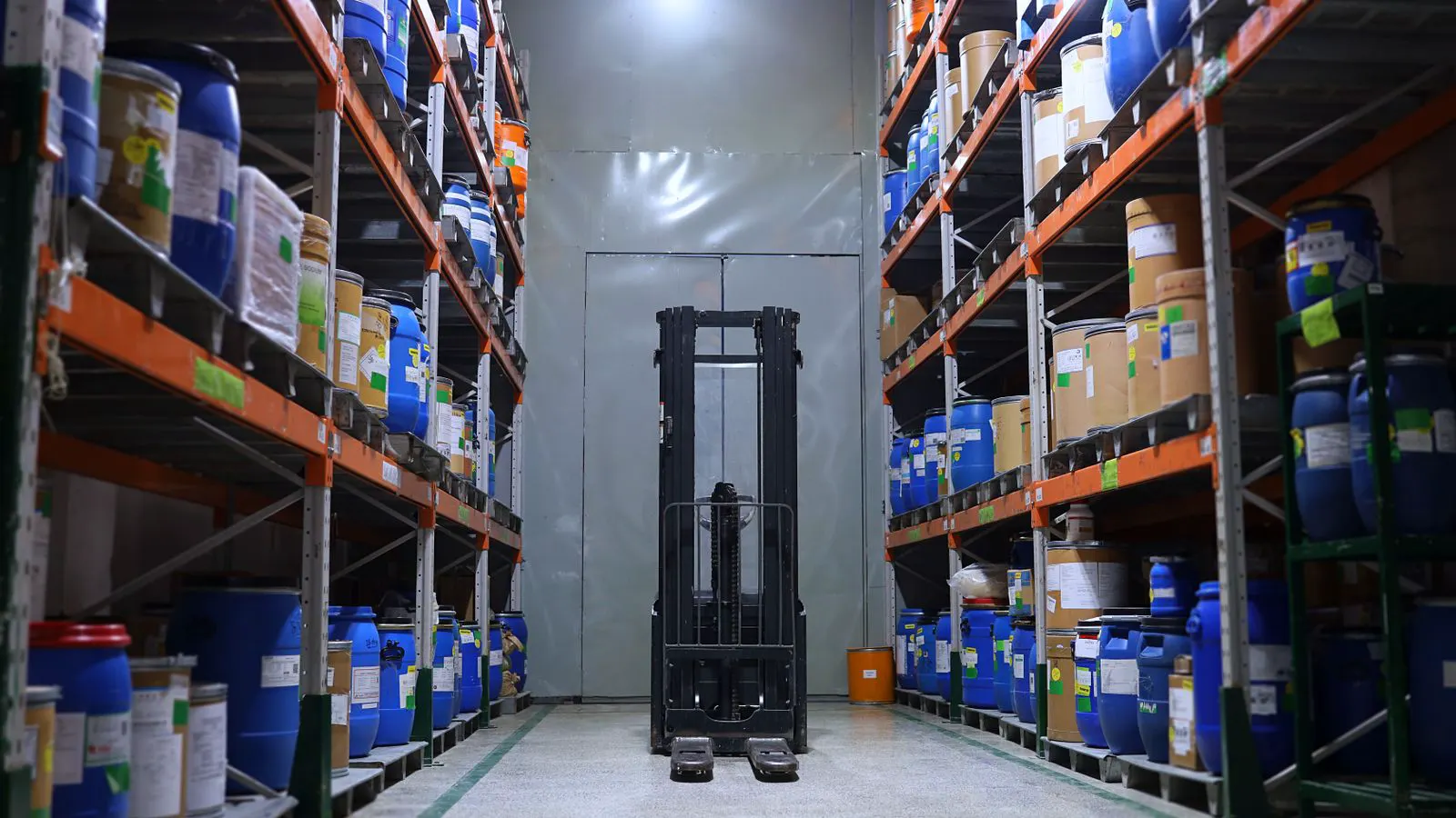 A counterbalance forklift moving through a warehouse aisle