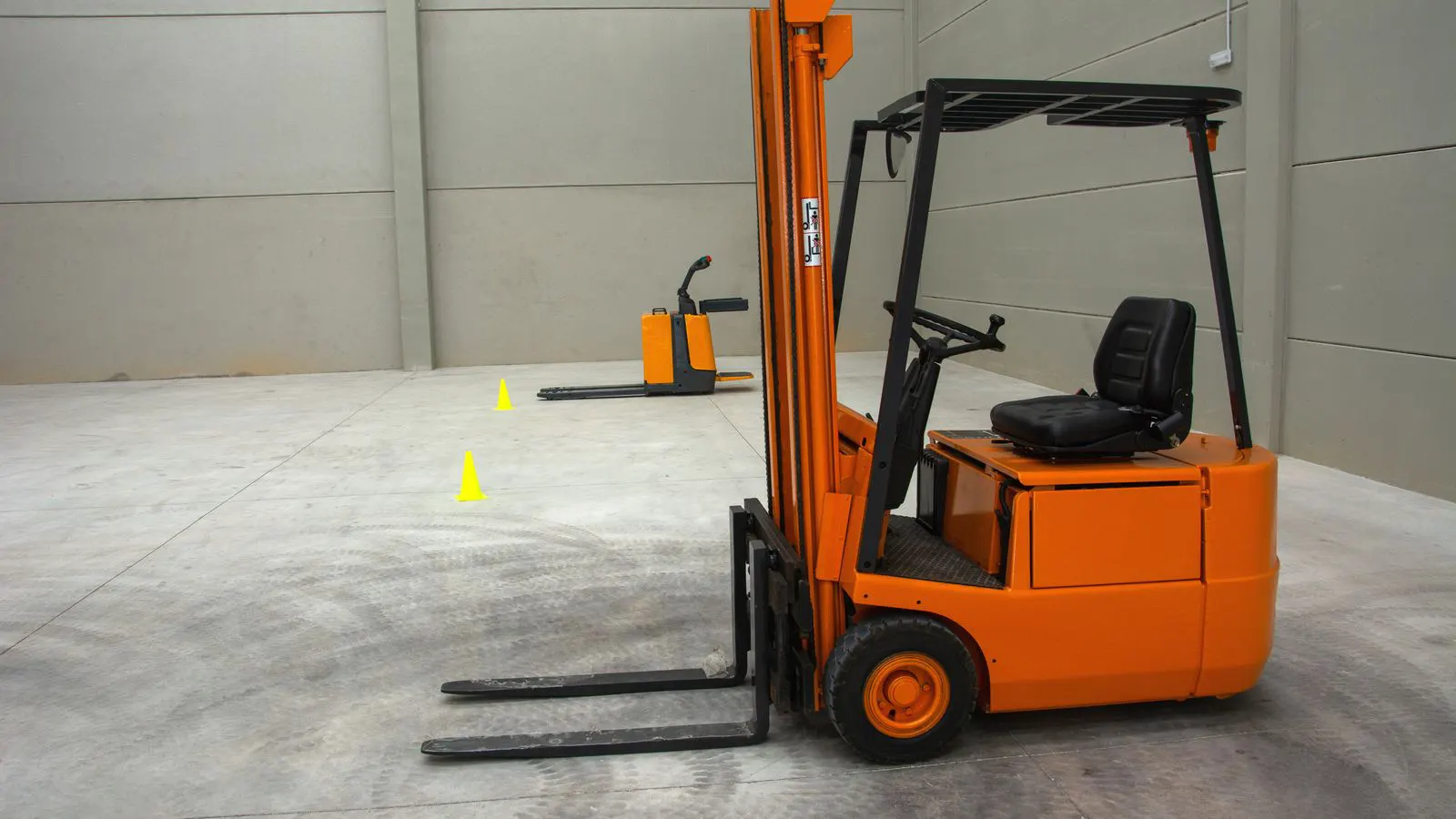 A forklift equipped with a pallet roller attachment moving a wooden pallet