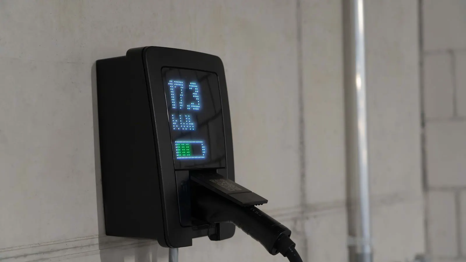 A large industrial battery sitting next to a charging rack in a warehouse.