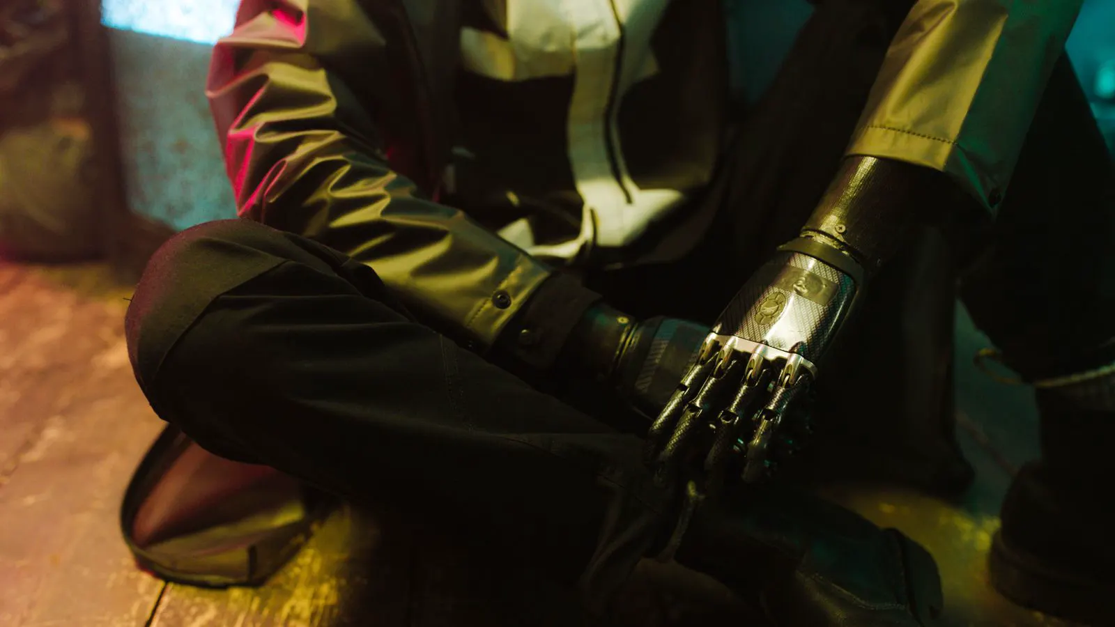 Close view of an operator holding a handheld controller near a robotic arm.