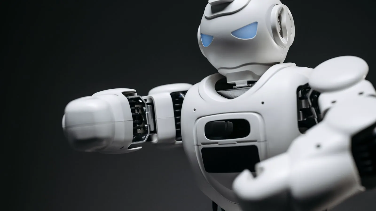 A white SCARA robot arm mounted on a factory floor