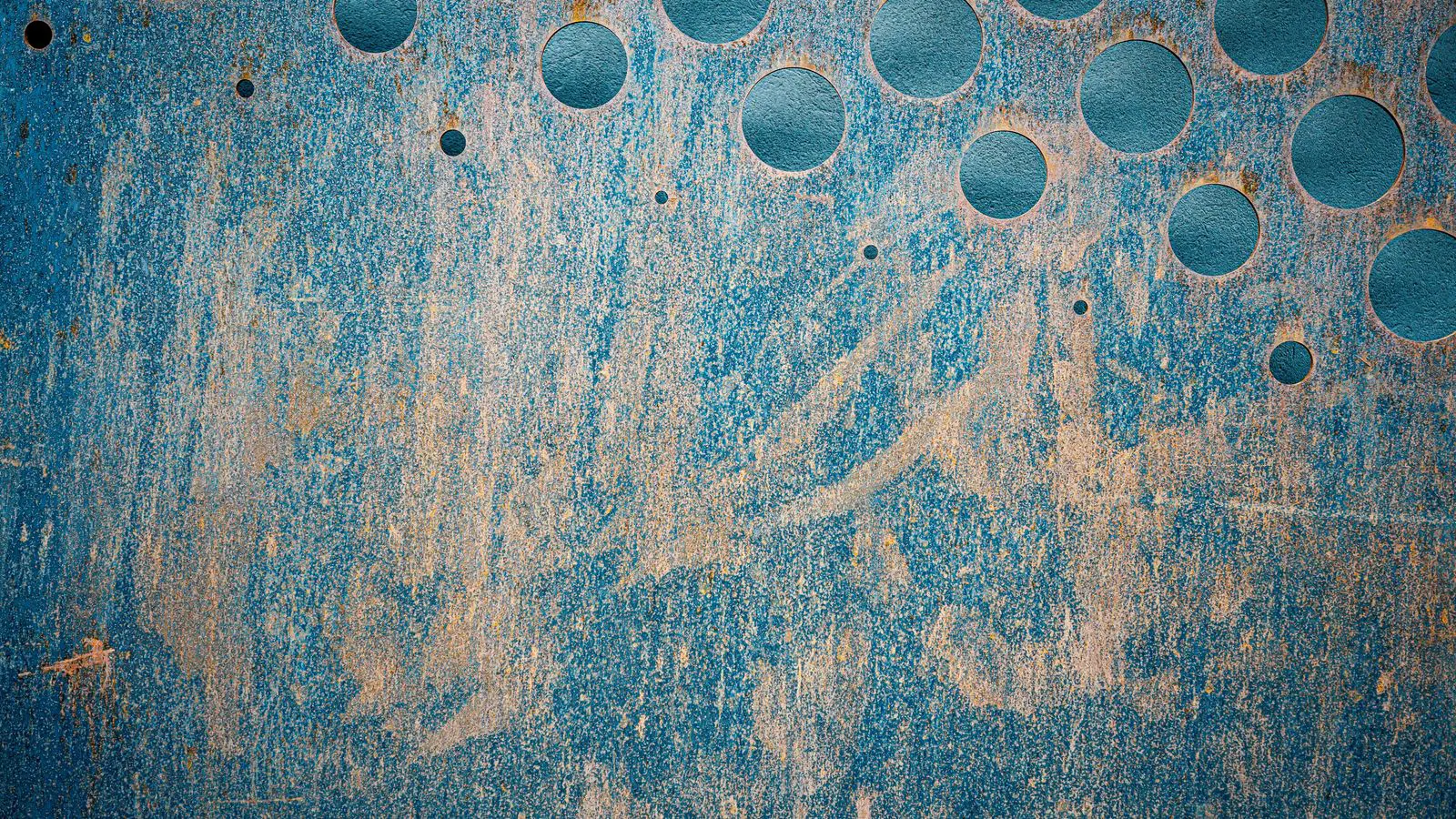 Metal parts suspended on racks inside a powder coating booth
