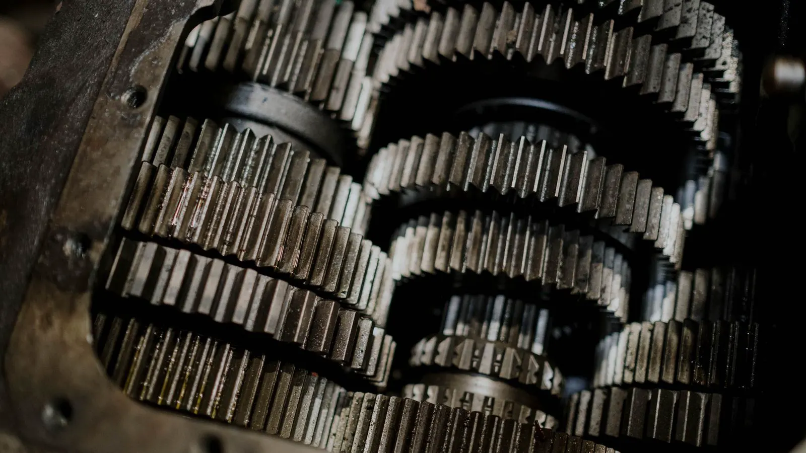 Metal components being cleaned by a high-velocity stream of abrasive media.