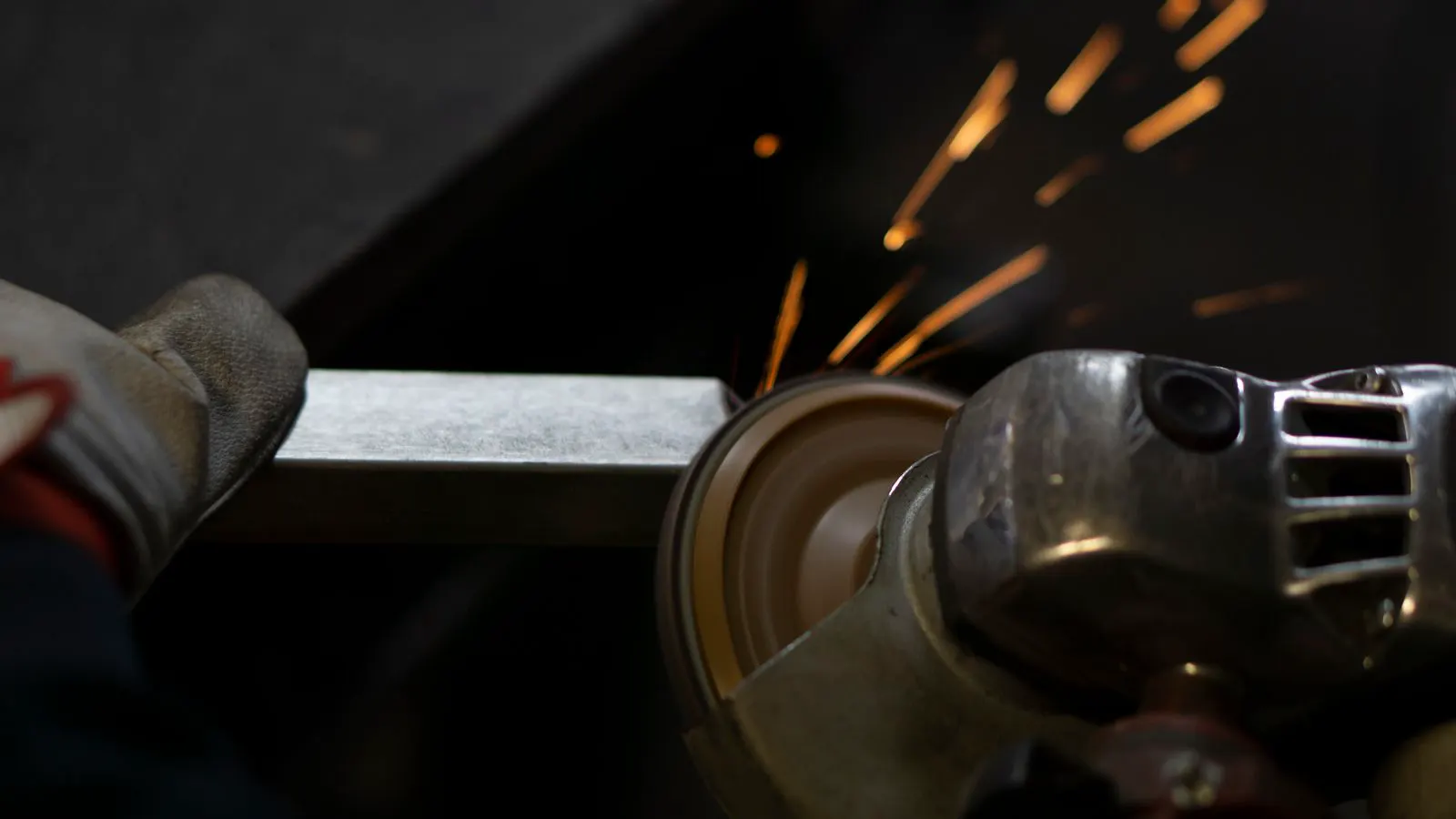 Powder coating being applied to metal parts inside a spray booth