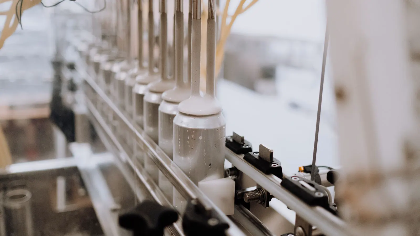 Stainless steel parts moving through a passivation line in a factory.