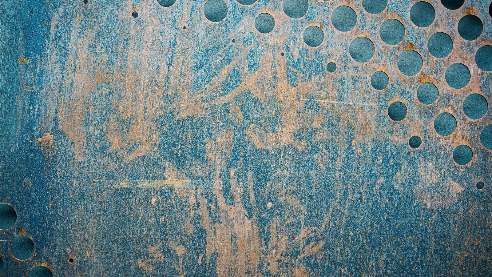Close-up of a metal plate showing inconsistent abrasive blasting texture