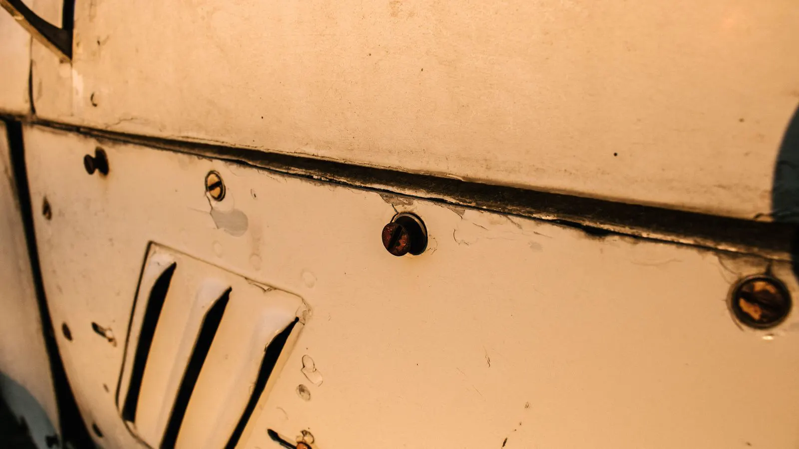 Inspector examining stainless steel fasteners on a metal workbench
