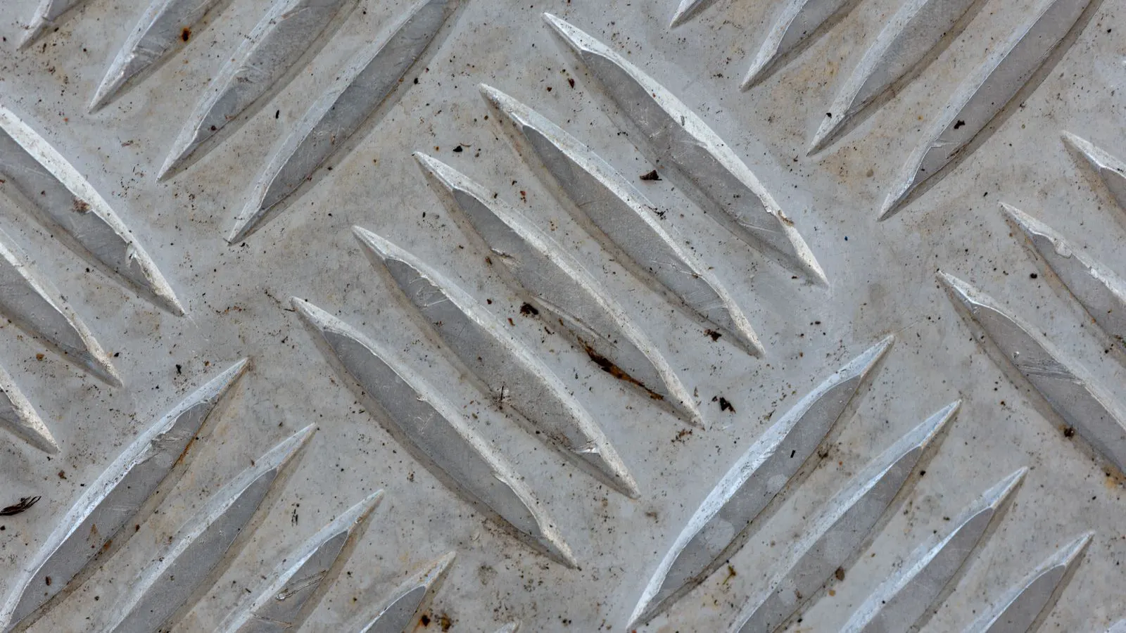 Stainless steel parts covered in abrasive grit during a blast