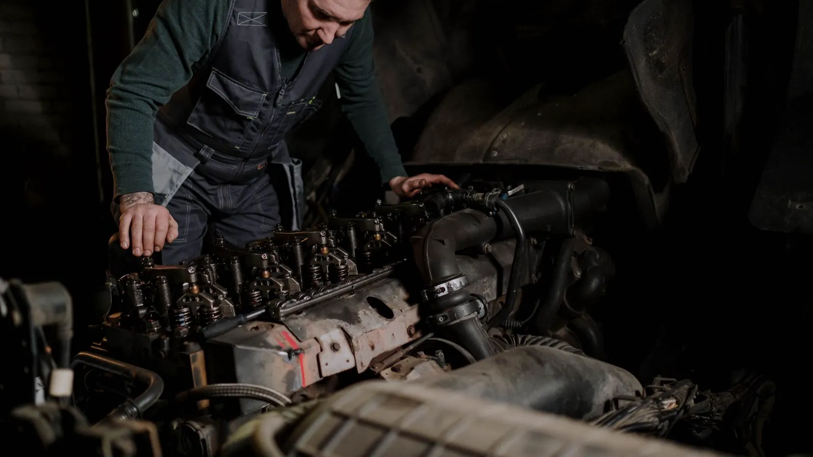 A technician inspecting the engine compartment of a diesel generator