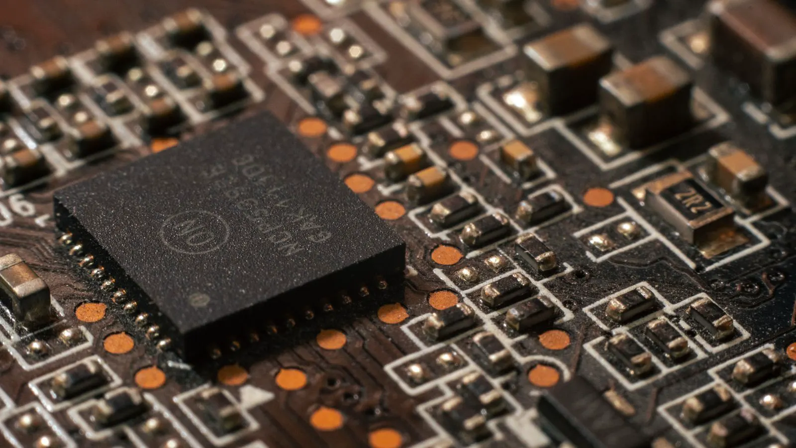 A magnified view of surface mount resistors showing color bands on a circuit board.