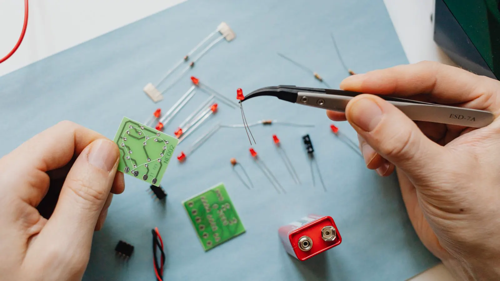 A printed sourcing checklist next to a magnifying glass over electronic components.