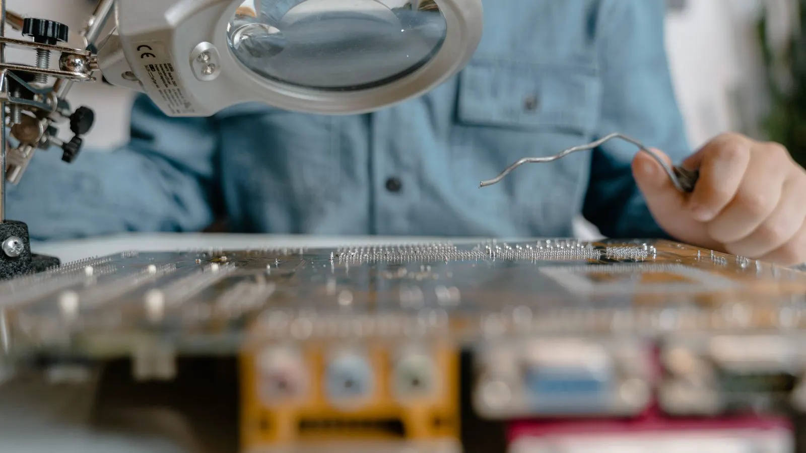 Engineer inspecting a wire harness assembly on a workbench.