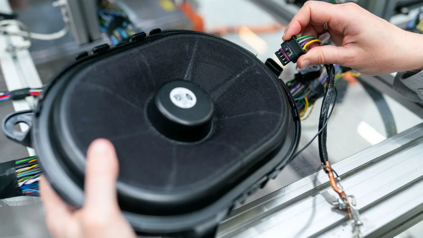 Engineer holding various copper wire gauges on workbench