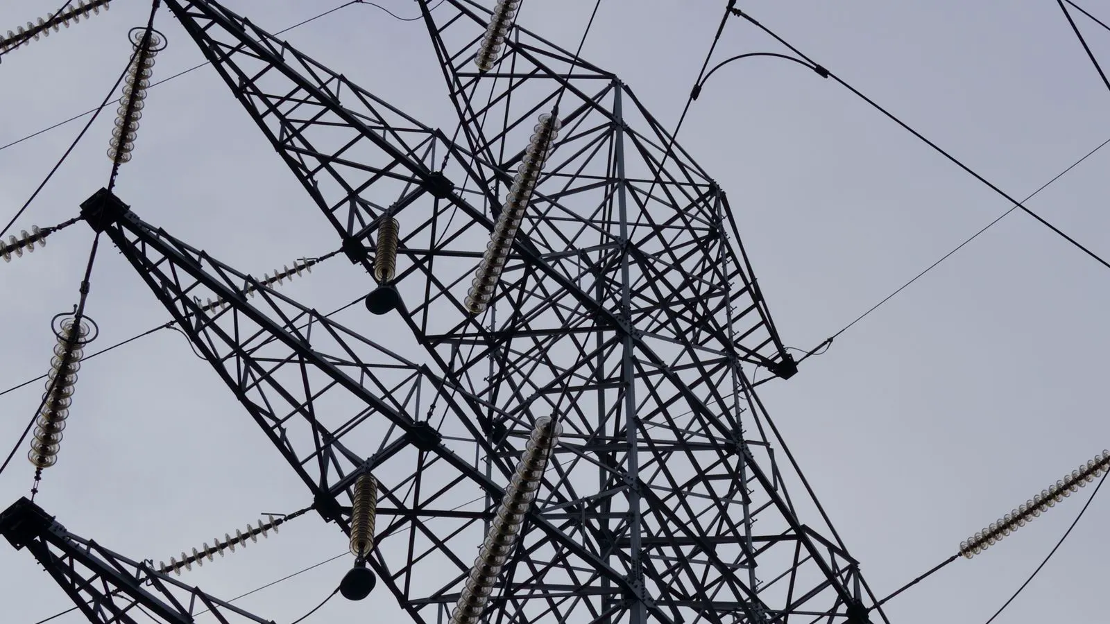 Engineer checks temperature readings near an industrial power supply unit
