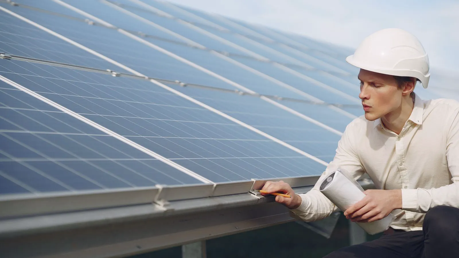 Technician holding infrared thermometer near circuit breaker