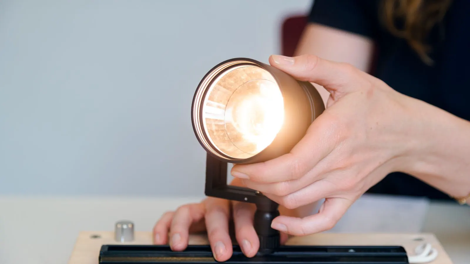 Engineer inspecting LED fixture on a laboratory calibration bench