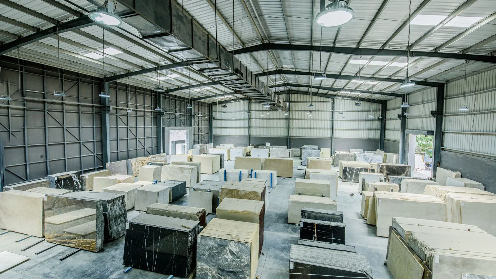 A modern LED high bay fixture illuminating a large warehouse floor.