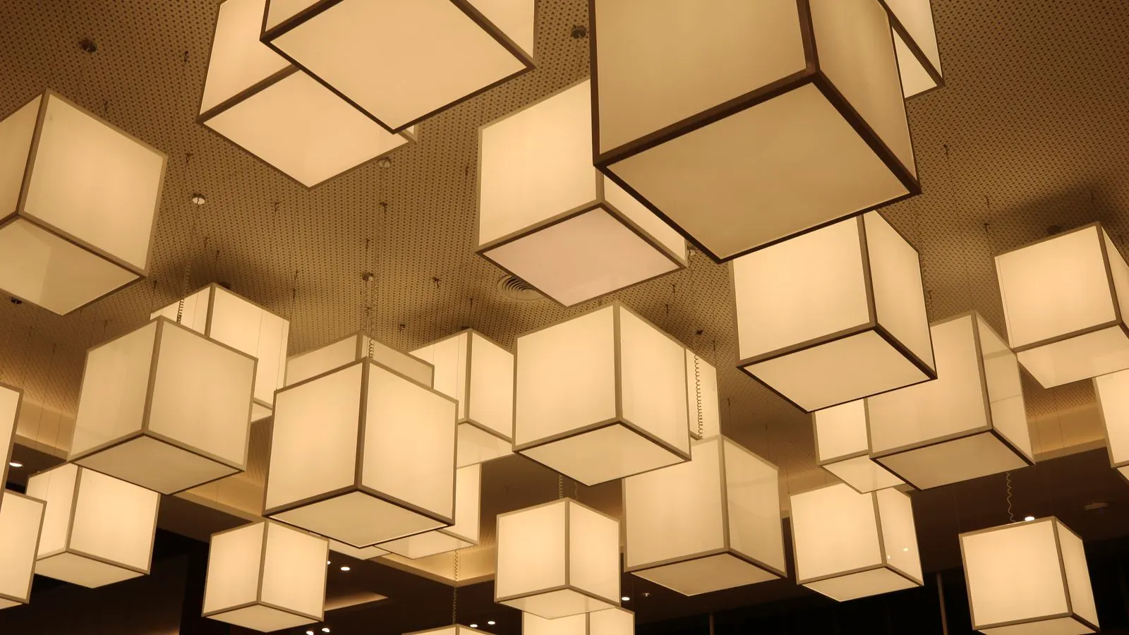 Linear and panel LED lights mounted above a busy store aisle