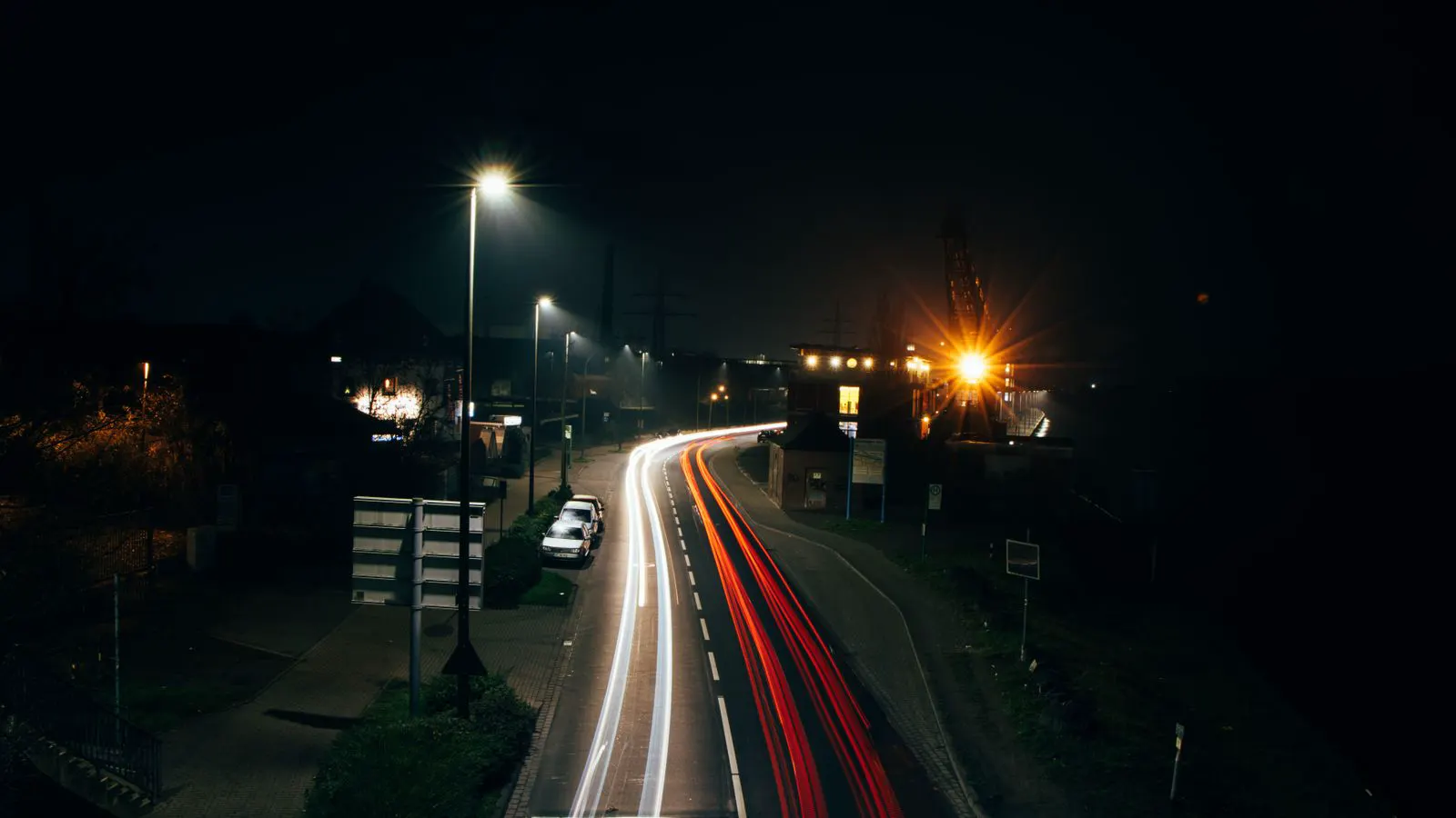 A street light fixture installed on a pole beside a paved road.