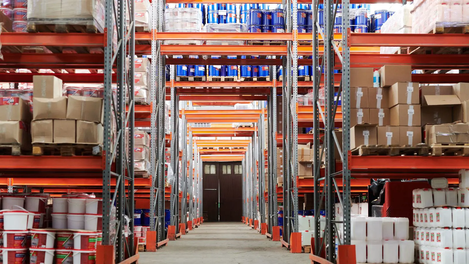 A large industrial warehouse filled with rows of LED lighting fixtures on shelving.