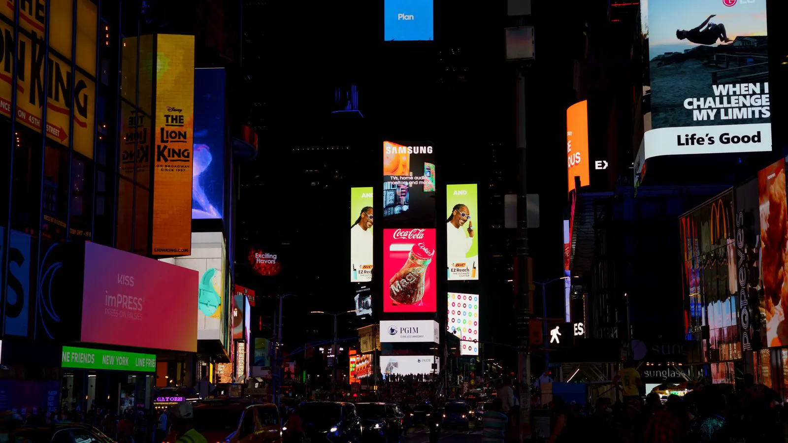 A large digital display screen mounted on a building at night