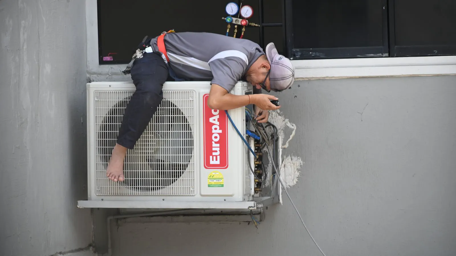 A technician using a tool to inspect an outdoor LED screen panel.