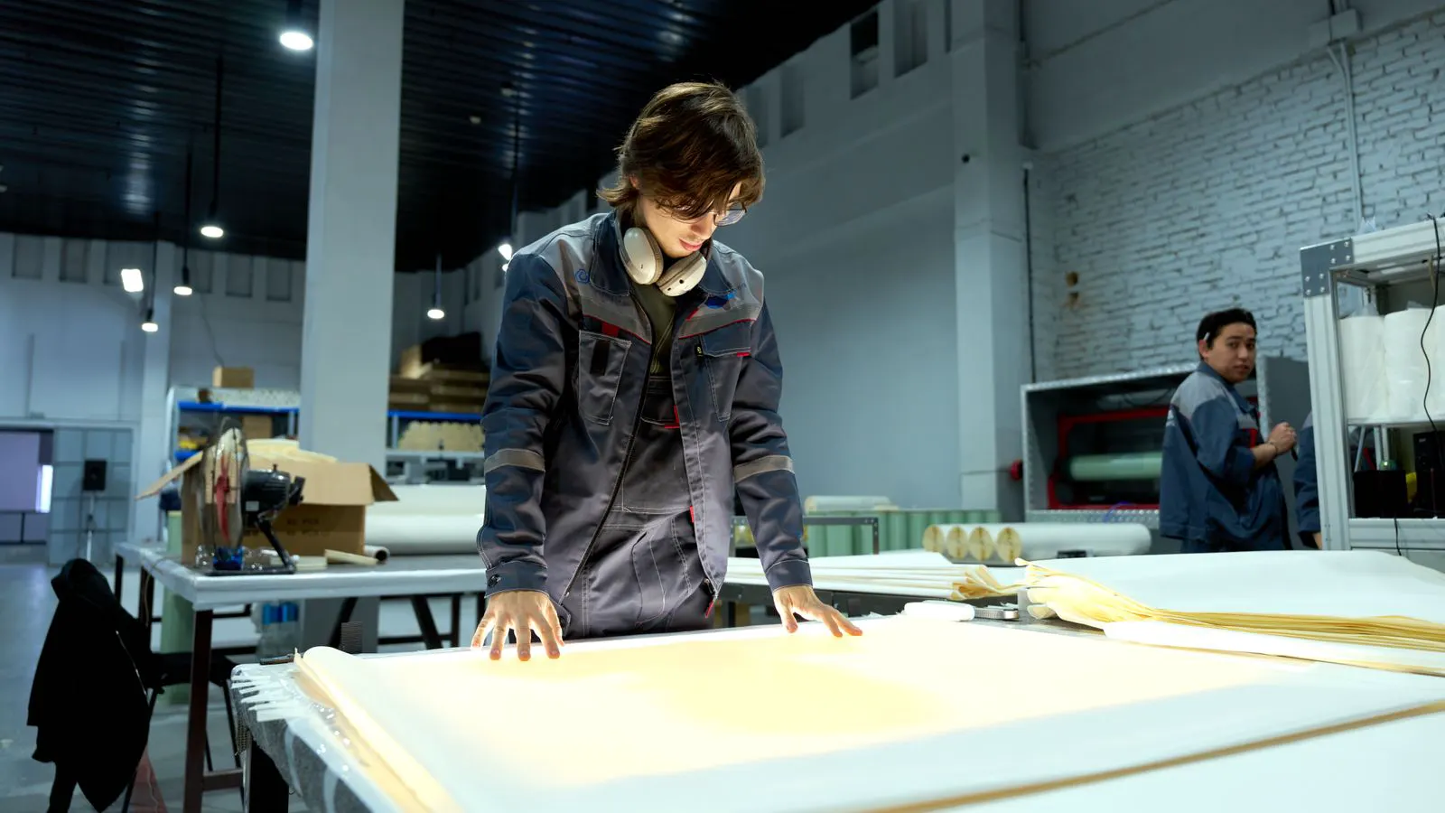 Worker inspecting pixel modules on an assembly line table