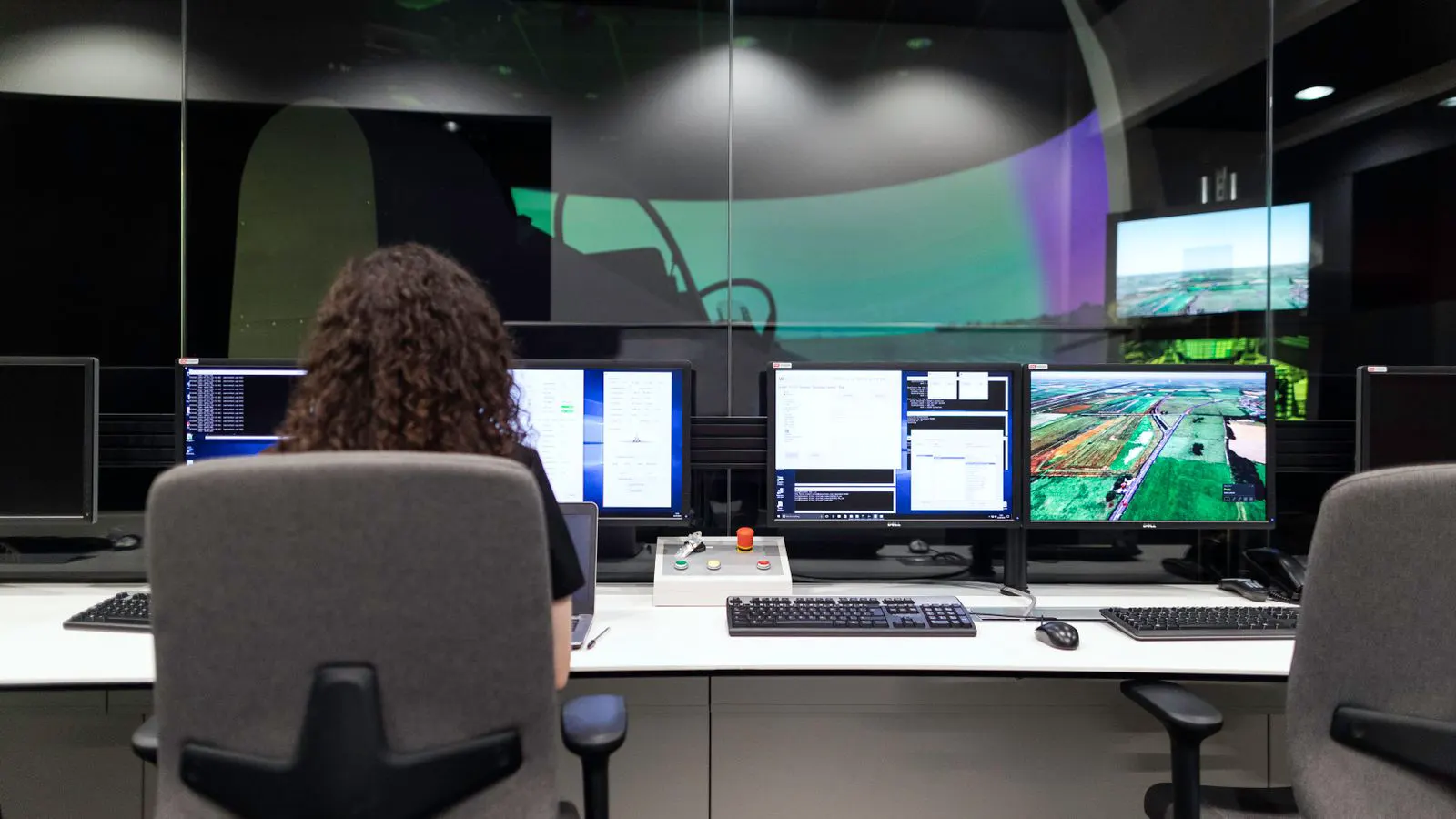 A professional control room with multiple monitors showing video playback.