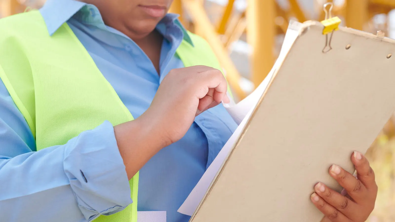 A project manager checks a printed certificate against a laptop screen.