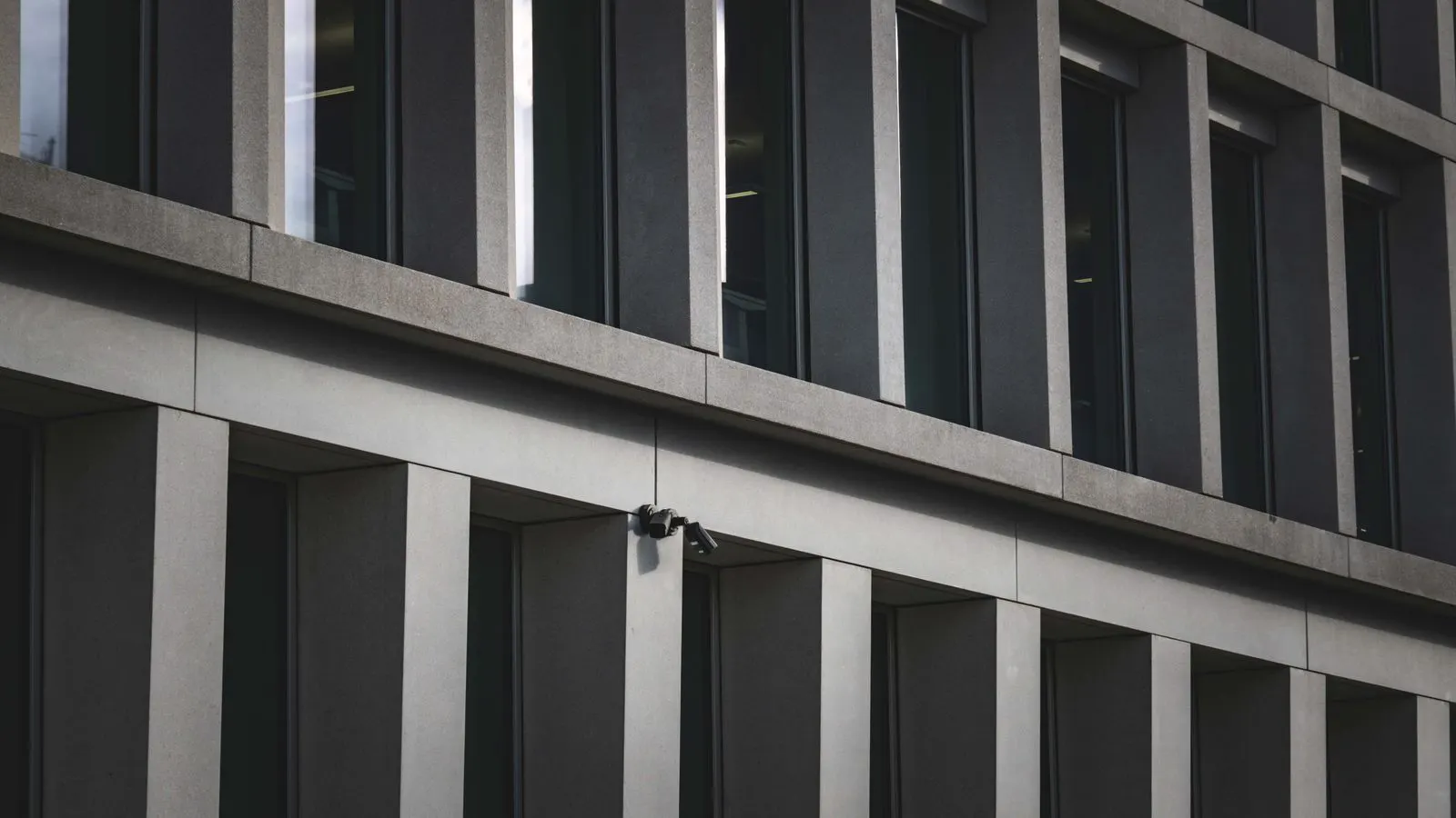 Technician mounting a new IP camera on a concrete wall bracket
