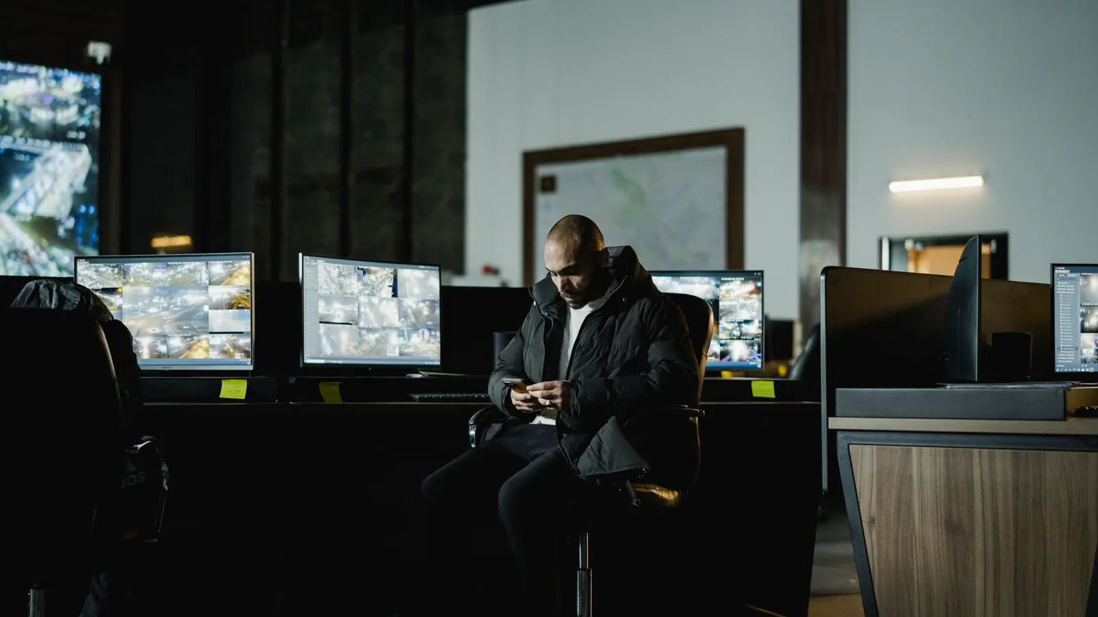 A control room with multiple monitors displaying live surveillance feeds.
