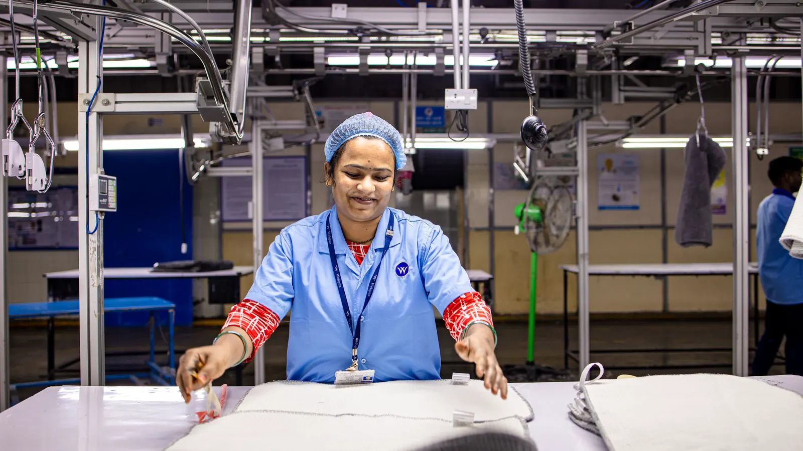Workers installing components on a large solar inverter unit in a factory.