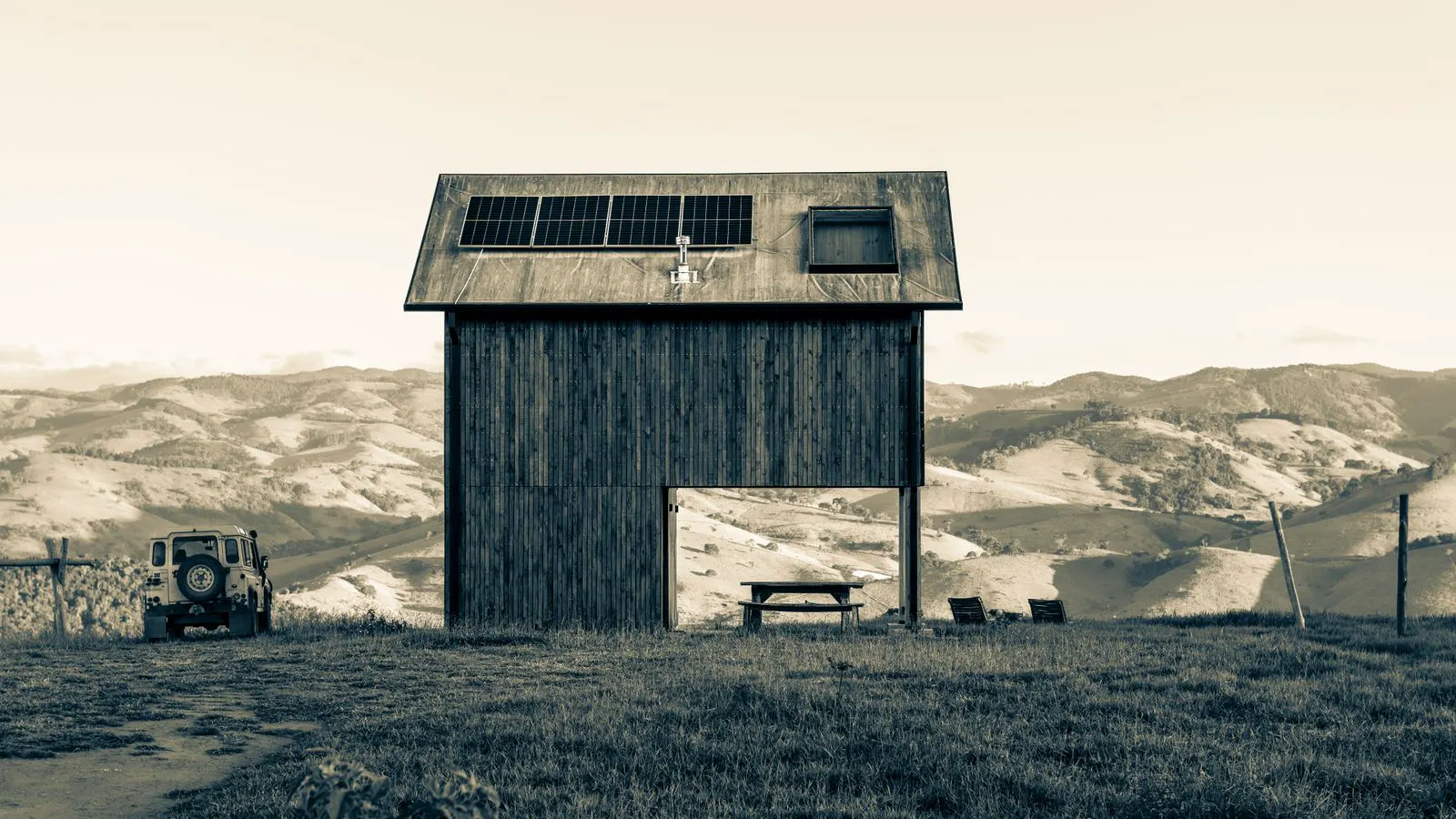 An off grid inverter mounted on a metal rack with battery cables